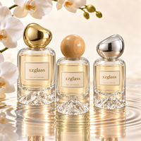 Flacon de parfum cylindrique de luxe en verre avec base sculptée en forme de montagne, bouchon en galet doré, sérigraphie, 30ml 50ml 100ml pour parfum
