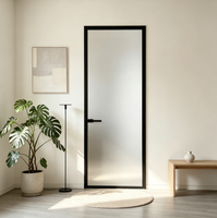 Porte de salle de bain à battants en verre dépoli, cadre en métal noir, poignée à barre, ouverture vers l'intérieur, porte de séparation intérieure moderne pour l'intimité