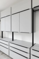 Meubles de cuisine modernes bicolores sur mesure, anthracite et chêne clair, sans poignées, avec îlot large et étagères LED, pour projet résidentiel