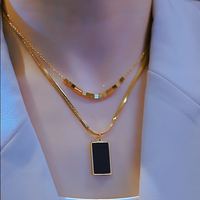 Collier à deux niveaux avec petites perles carrées dorées et chaîne serpent rectangulaire noire