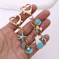 Nouveau rouge à lèvres tendance en forme de goutte d'huile, petit pendentif chat bleu, porte-clés en perles, accessoires pour sacs pour femmes