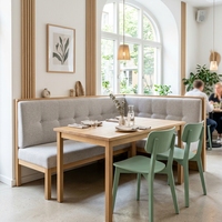 Ensemble de banquettes de restaurant contemporain de luxe avec canapé en cuir capitonné crème et table en marbre blanc avec chaises en velours