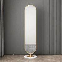 Miroir sur pied minimaliste sans cadre avec piédestal en marbre et bordure dorée pour usage domestique