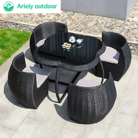 Fauteuil rond de bistrot français d'extérieur en métal, rotin, osier, jardin fleuri
