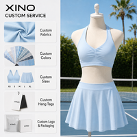 Ensemble de sport 2 pièces uni pour femme, avec brassière de sport dos nageur froncée à l'avant et jupe-short fluide taille haute avec short intégré, extensible dans quatre directions