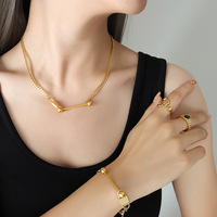 Ensemble collier et bracelet en acier titane plaqué or 18 carats avec pendentif balle d'équilibre irrégulière et clé