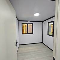 Maison modulaire préfabriquée moderne, maison préfabriquée à ossature en acier noir, maison en kit, bande lumineuse LED, mur en placage de pierre, cour arrière