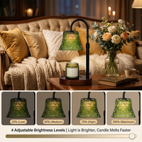 Lampe chauffe-bougie en verre vert style forêt, bras en métal noir mat réglable en hauteur, base en bois irrégulière en forme de nuage