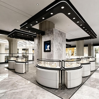 Comptoir d'exposition incurvé de luxe en verre avec base en marbre, cadre en métal noir et éclairage LED pour boutique de bijoux