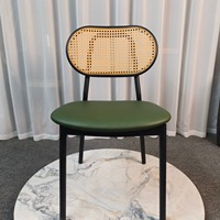 Chaise de salle à manger moderne sans accoudoirs avec dossier ovale en rotin et coussin rembourré sur structure noire mate