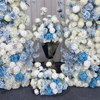 Dekorasi Latar Belakang Tempat Pernikahan Romantis dengan Gapura Bunga Buatan Tangan Berwarna Biru dan Putih Gradasi Mawar dan Hydrangea.