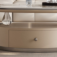 Ensemble de table basse ovale moderne en pierre avec base abstraite en acier inoxydable gris, plateau beige et rangement avec tiroirs
