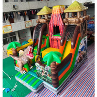Structure gonflable à thème volcan dinosaure avec toboggan, combo de jeux gonflables pour enfants, idéal pour les fêtes en plein air et les aires de jeux.