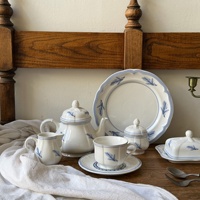Service de table en céramique bleu vintage français avec motif plume en relief, comprenant un kit de tasses, une théière cannelée et des assiettes creuses, compatible micro-ondes
