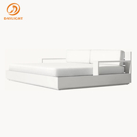 Lit de repos de luxe en teck avec table d'appoint intégrée et plateforme à profil bas, coussin géométrique, salon extérieur moderne pour villa minimaliste