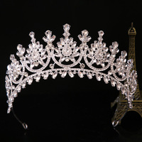 Couronne de feuilles vertes avec des pierres vertes en forme de larme et des pierres noires sur un motif enroulé doré, pour la fête de la Saint-Patrick