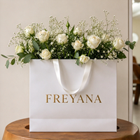 Sac cadeau en papier blanc crème avec ruban satiné champagne, poignée personnalisée, logo calligraphié, motif floral