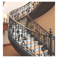 Escalier en colimaçon courbé sur mesure avec marches en acajou, balustres en fer forgé et main courante en laiton poli