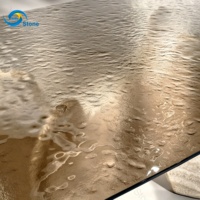 Table de salle à manger de luxe en gros, table ovale moderne avec plateau en verre effet vague d'eau et base en travertin pour villa et hôtel