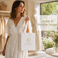 Sac en papier cartonné blanc personnalisé avec poignée en ruban, logo en feuille d'or, finition mate pour l'emballage de vêtements de boutique, vente en gros