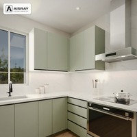 Meuble de cuisine minimaliste en PVC en forme de U avec portes en panneaux vert sauge, boîtes en MDF et poignées intégrées