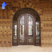 Porte d'entrée double classique en fer forgé cintrée avec panneaux de verre à motifs raffinés pour maison de luxe