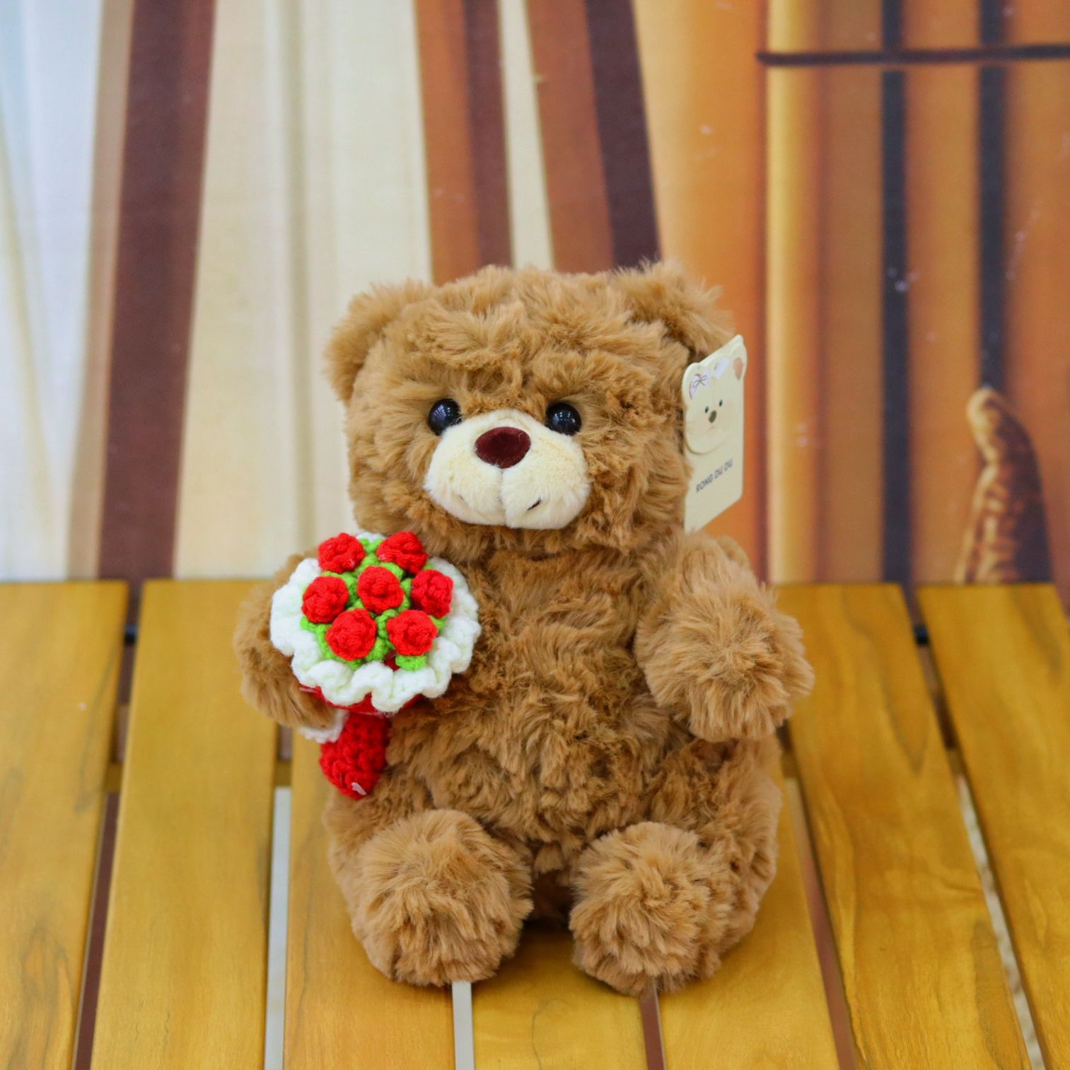 ours brun avec bouquet de fleurs rouges