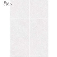 Carrelage grand format en porcelaine marbrée gris clair, pleine masse, haute brillance, antidérapant, pour sols de villas, salons et chambres.