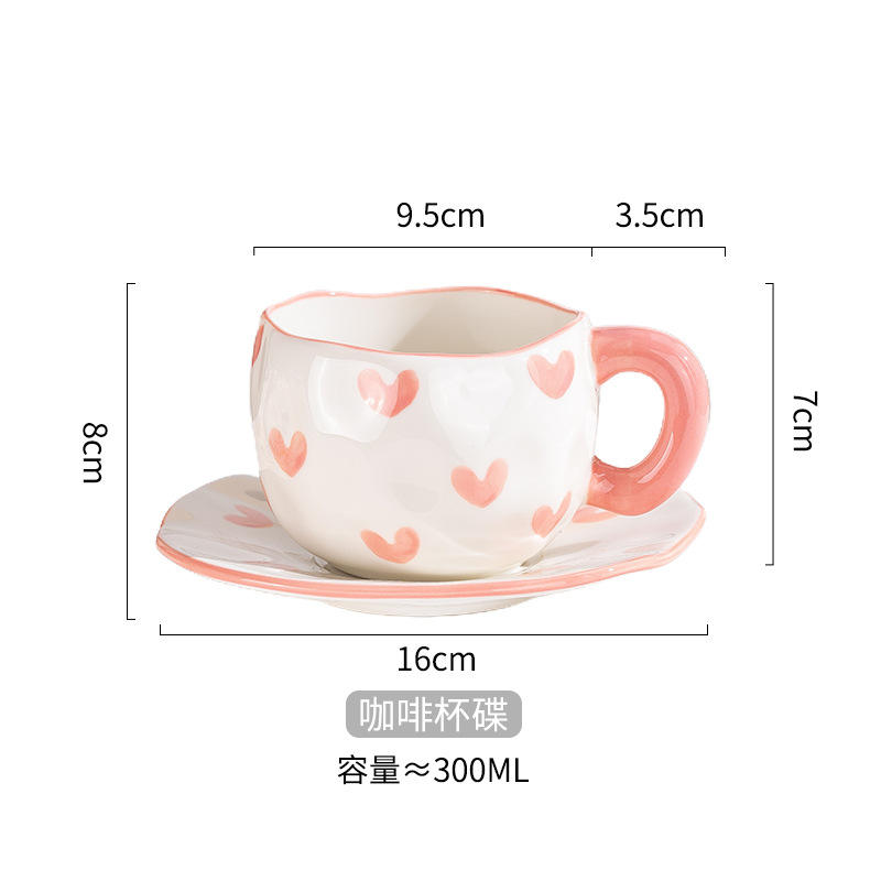 Taza de café y plato moldeados a mano con forma de corazón rosa.