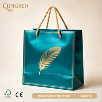 Sacs cadeaux en papier métallisé bleu sarcelle personnalisés OEM avec motif plume dorée et poignées torsadées pour boutiques de luxe