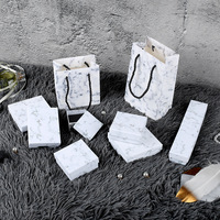 Boîte cadeau personnalisée avec logo, base et couvercle en papier mat, dessus et dessous en carton, et doublure en mousse. Boîte à bijoux découpée au laser