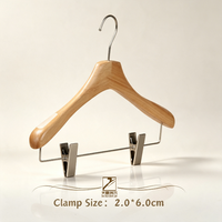 Cintre classique en bois naturel avec double bretelles, bandes antidérapantes et sous-clip pour l'affichage des vêtements