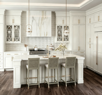 Armoire de cuisine sur mesure de luxe blanche à panneaux surélevés avec porte en verre décorative, quincaillerie dorée, grand îlot de cuisine pour la rénovation de la maison