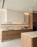 Ensemble d'armoires de cuisine minimalistes haut de gamme, meubles en bois chaud sans poignées, crédence en pierre de travertin pour projets de rénovation