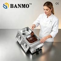 Machine à tempérer et à faire fondre le chocolat industrielle BANMO avec corps en acier inoxydable, bouton de température réglable et plusieurs réservoirs.