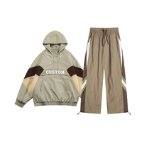 Ensemble survêtement streetwear pour homme : veste coupe-vent en nylon personnalisée avec logo brodé et patchwork, et pantalon baggy