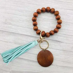 Llavero con borlas y cuentas de madera, pulsera con monograma, llavero con flecos