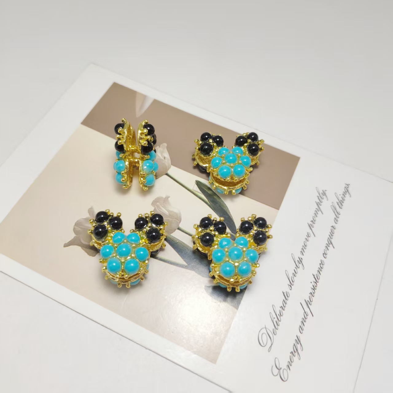 Oreilles en perles noires dorées et visage en perles bleues