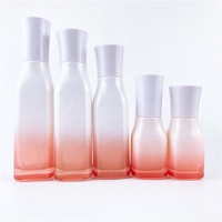 Flacons cosmétiques en verre rose dégradé avec bouchon et applicateur, emballage moderne pour usage industriel