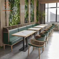 Ensemble de mobilier pour café-restaurant : banquette en cuir vert, table à manger en marbre, fauteuils en rotin à structure en bois pour restaurant
