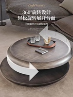 Table basse rotative à double niveau en acier inoxydable, design italien, style minimaliste et artistique, pour salon de luxe.