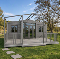Maison conteneur pliable extensible en grain de bois gris anthracite avec terrasse, balustrades et structure de pergola pour le glamping rural