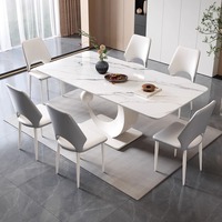 Table à manger de luxe de conception italienne avec plateau en pierre frittée grise et base artistique unique en forme de C pour mobilier de villa moderne et d'hôtel.