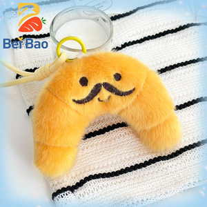 Fabricant de peluches : Porte-clés en peluche mignon en forme de <span class=keywords><strong>croissant</strong></span> de 4 pouces avec broderie de moustache, pendentif de sac en forme de pain, pour machine à griffes - Product Image 1