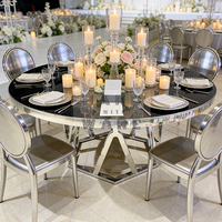 Table de salle à manger ronde de luxe avec plateau en verre noir, base géométrique argentée et structure en acier inoxydable