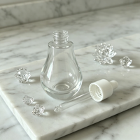 Flacon compte-gouttes en verre transparent rond créatif de 30 ml avec étiquettes personnalisées OEM/ODM pour le stockage d'huiles essentielles, de parfums et d'essences