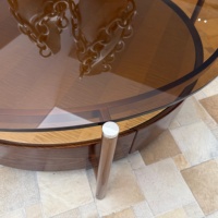 Table basse ronde moderne à deux niveaux avec surface en verre ambré, pieds en métal cuivré et base en bois à motif étoilé