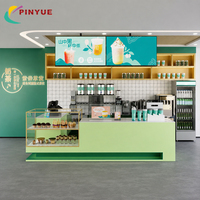 Comptoir de magasin de bubble tea vert menthe avec étagères de présentation en verre, panneaux de menu numériques, solution professionnelle tout-en-un pour la vente au détail