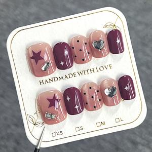 Lot de 10 faux ongles en acrylique pré-dessinés, forme amande, avec motifs œil de chat rose nude, étoiles, cœurs, pois et cristaux noirs - Product Image 1