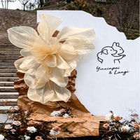 Fleur géante en organza sur mesure de luxe pour la décoration de mariage et les vitrines.